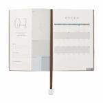 Artículos de merchandising empresarial con presentación refinada y empaque profesional, agenda semanal clásica 2027 café